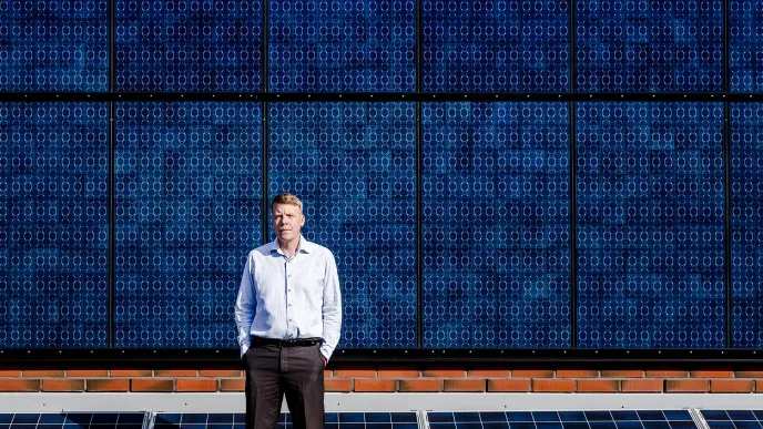  LUT-yliopiston vuoden 2022 innovaatioprofessori Jero Ahola, kuvattu aurinkopaneelien edessä Lappeenrannan kampuksella