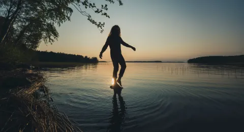 LUT University student balancing on a rock above water 