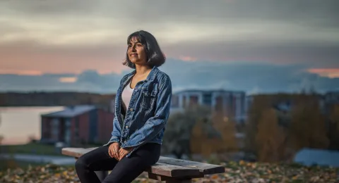 LUT University student sitting on a bench in a urban fall scenery