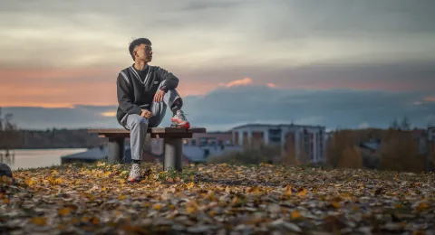 LUT University sitting on a bench in a fall scenery