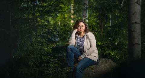 LUT University student sitting in the forest