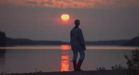 Student in sunset at lake Saimaa Lappeenranta LUT University