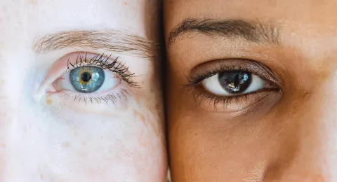 Light and dark skinned persons staring at a camera