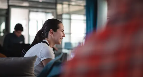 People sitting in a room, a woman smiling