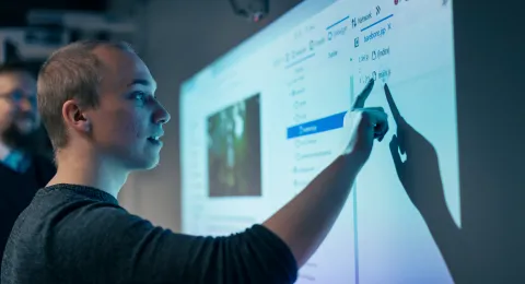 Opiskelija tietotekniikan testilaboratoriossa.