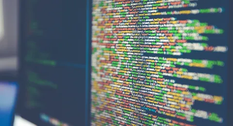 Tietokoneen näytöllä näkyy koodia.