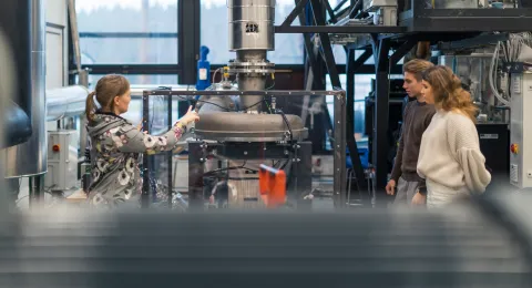 Energiatekniikan opettaja ja opiskelijoita laboratoriossa.