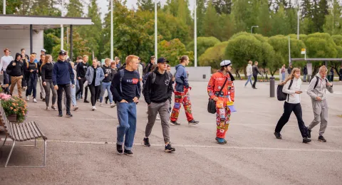 Opiskelijoita kävelemässä yliopiston pihalla