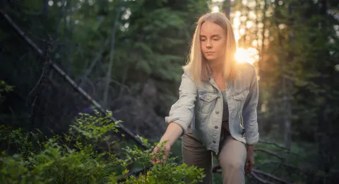 Opiskelija kävelemässä metsässä