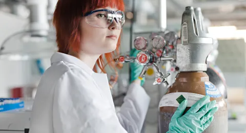 Kemiantekniikan opiskelija laboratoriossa suojalasit päässä.