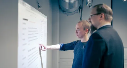 Opiskelija ja opettaja tietotekniikan käytettävyyslaboratoriossa.