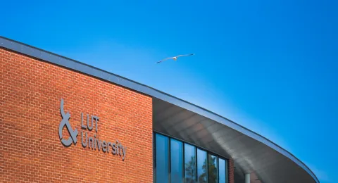 LUT University Lappeenranta Campus from outside with a seagull flying on the sky