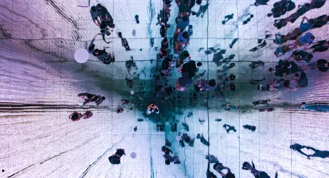 kuva peilikatosta, josta heijastuu ihmisiä, view of ceiling mirror showing people