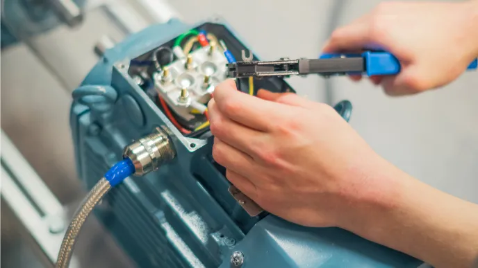 Electrical Engineering student fixes motor in laboratory at LUT campus.