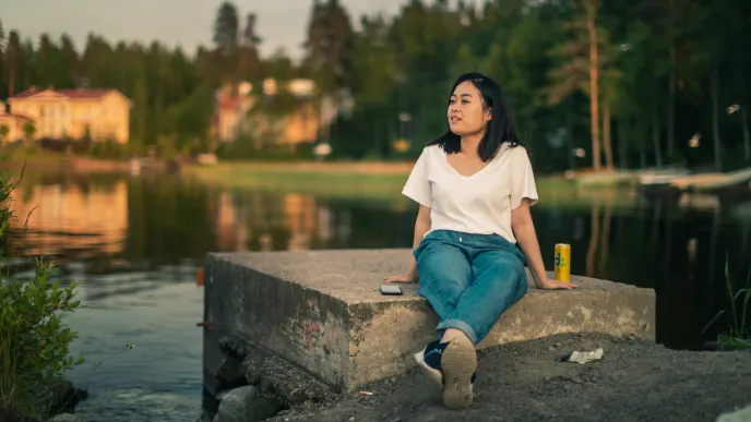 LUT University master&#039;s student sitting on a concrete block at the shore