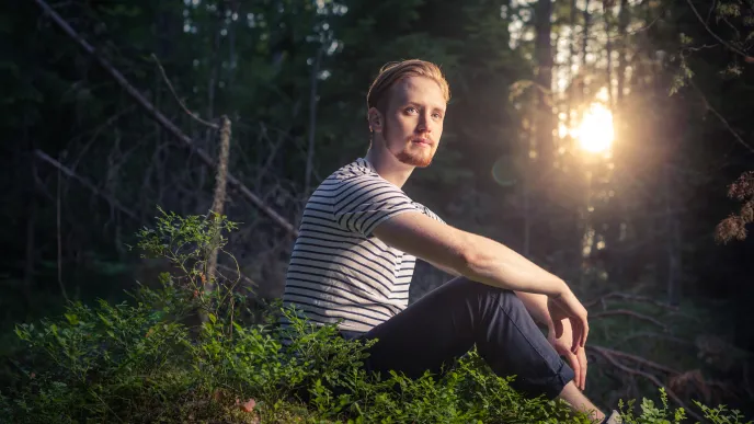 LUT University student sitting in a forest at sunset 