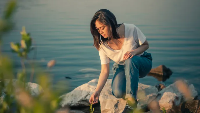 LUT University student examining plant at shore