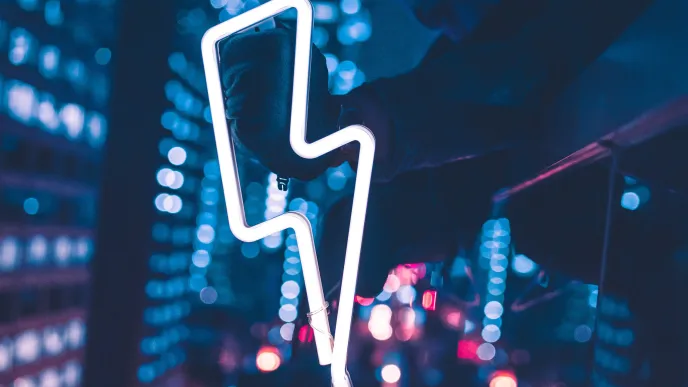 Henkilö pitelee salaman muotoista valokylttiä.