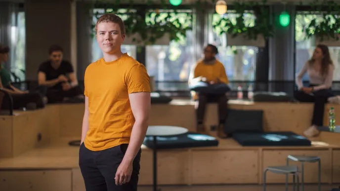 Opiskelija seisoo TEK Loungessa.