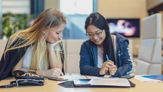 Kaksi opiskelijaa tekemässä tehtäviä.