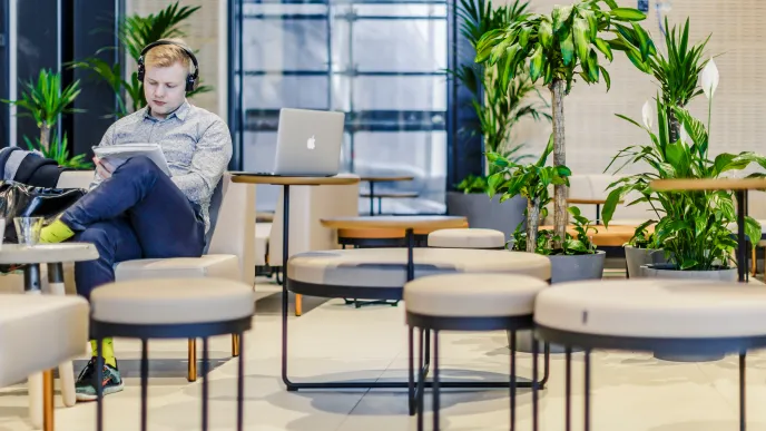 Opiskelija istuu tietokone sylissään.