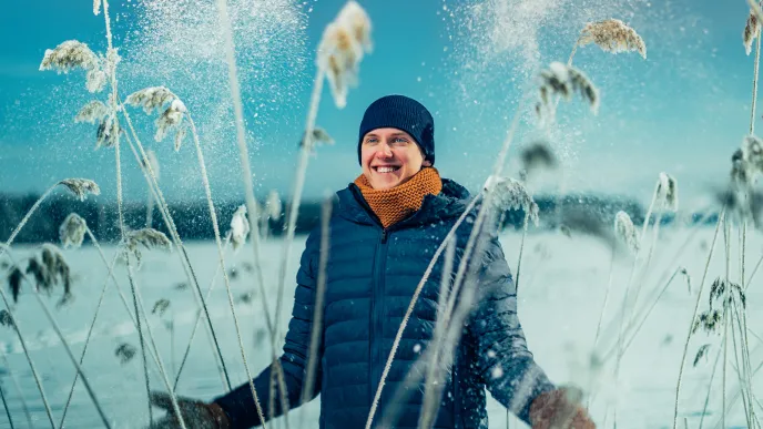 A happy person standing in snow during winter 