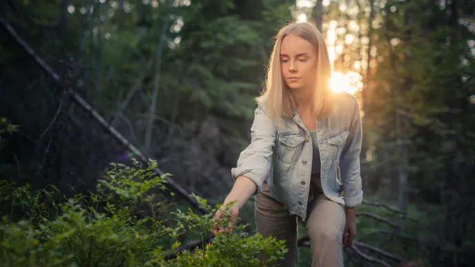 Opiskelija kävelemässä metsässä