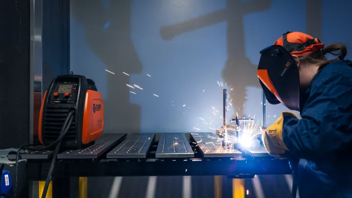 Henkilö hitsaa ja kipinät lentävät.