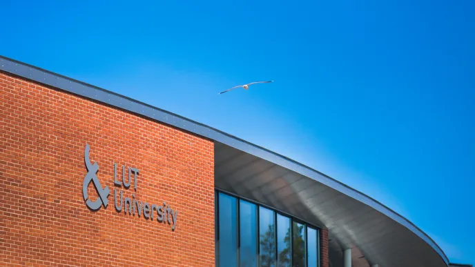 LUT University Lappeenranta Campus from outside with a seagull flying on the sky