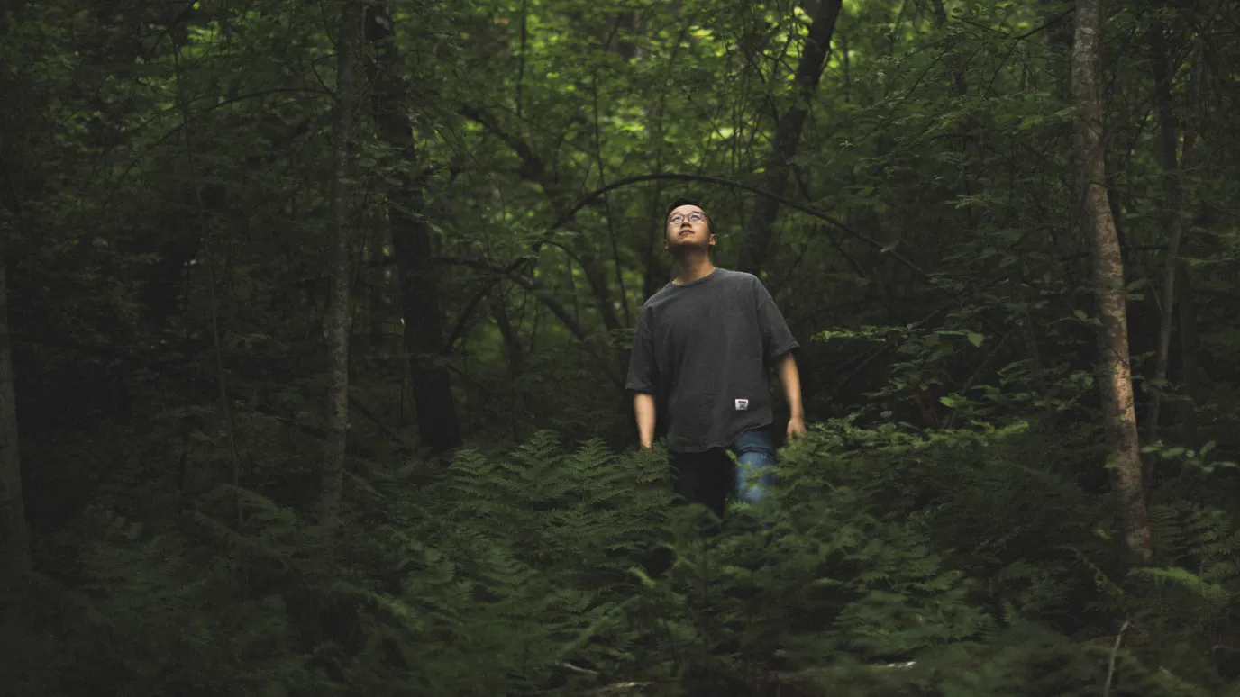 LUT University student in a forest watching the sky