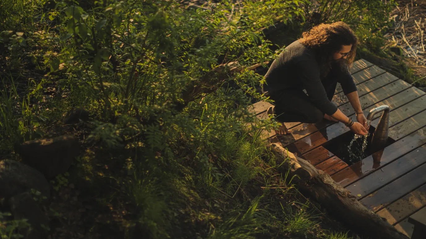 Student washing hands in spring nature in Lappeenranta