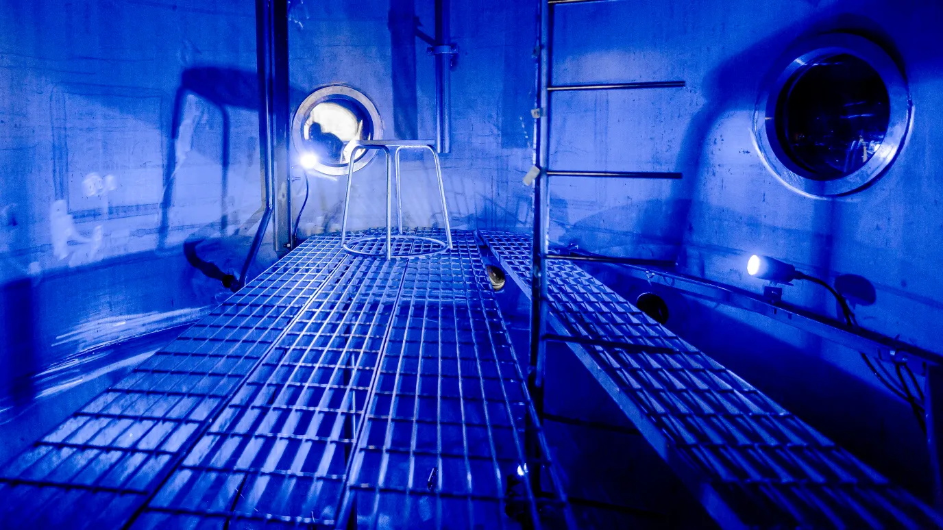 Ydinlaboratorion säiliön sisäpuoli valaistuna sinisellä valolla.