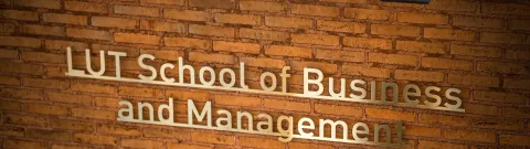 LUT School of Business and Management logo on a brick wall