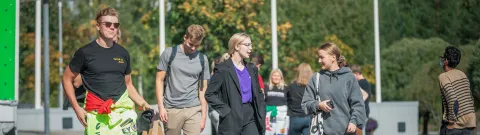 Opiskelijoita kävelemässä yliopiston pihalla.