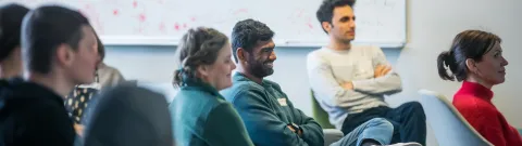 Henkilöitä kuuntelemassa luentoa.