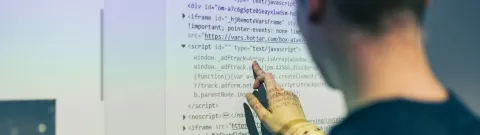 Opiskelija tietotekniikan testilaboratoriossa.