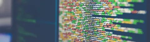 Tietokoneen näytöllä näkyy koodia.