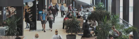 Opiskelijoita kävelemässä yliopiston käytävällä.