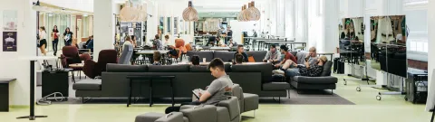 Ihmisiä istumassa Lahden kampuksen tapahtuma-areenalla.