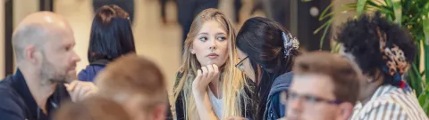 Opiskelija istuu yliopiston kahvilassa.