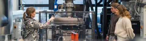 Opettaja ja opiskelijoita energiatekniikan laboratoriossa.