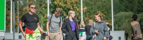 Opiskelijoita kävelemässä yliopiston pihalla.