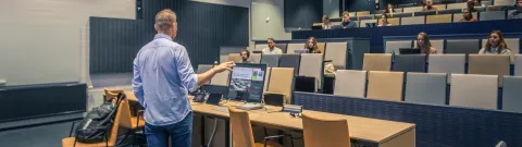 Opettaja ja opiskelijoita luentosalissa.