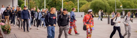 Opiskelijoita kävelemässä yliopiston pihalla.