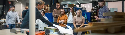 Opiskelijoita Jamie Hyneman Centerissä. Opettaja esittelee moottoripyörää.