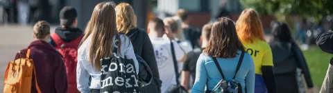 Opiskelijoita kävelemässä yliopiston pihalla.