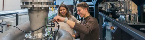 Energiatekniikan opiskelijoita tutustumassa laboratorion laitteisiin.