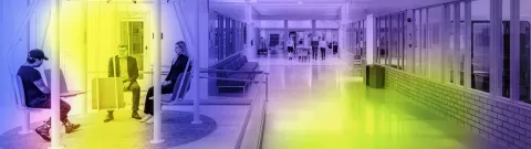 Kampuksen pitkä käytävä ja ihmisiä istumassa penkeillä käytävän vieressä.