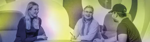 Henkilöt istuvat pyöreän pöydän ääressä ja keskustelevat.